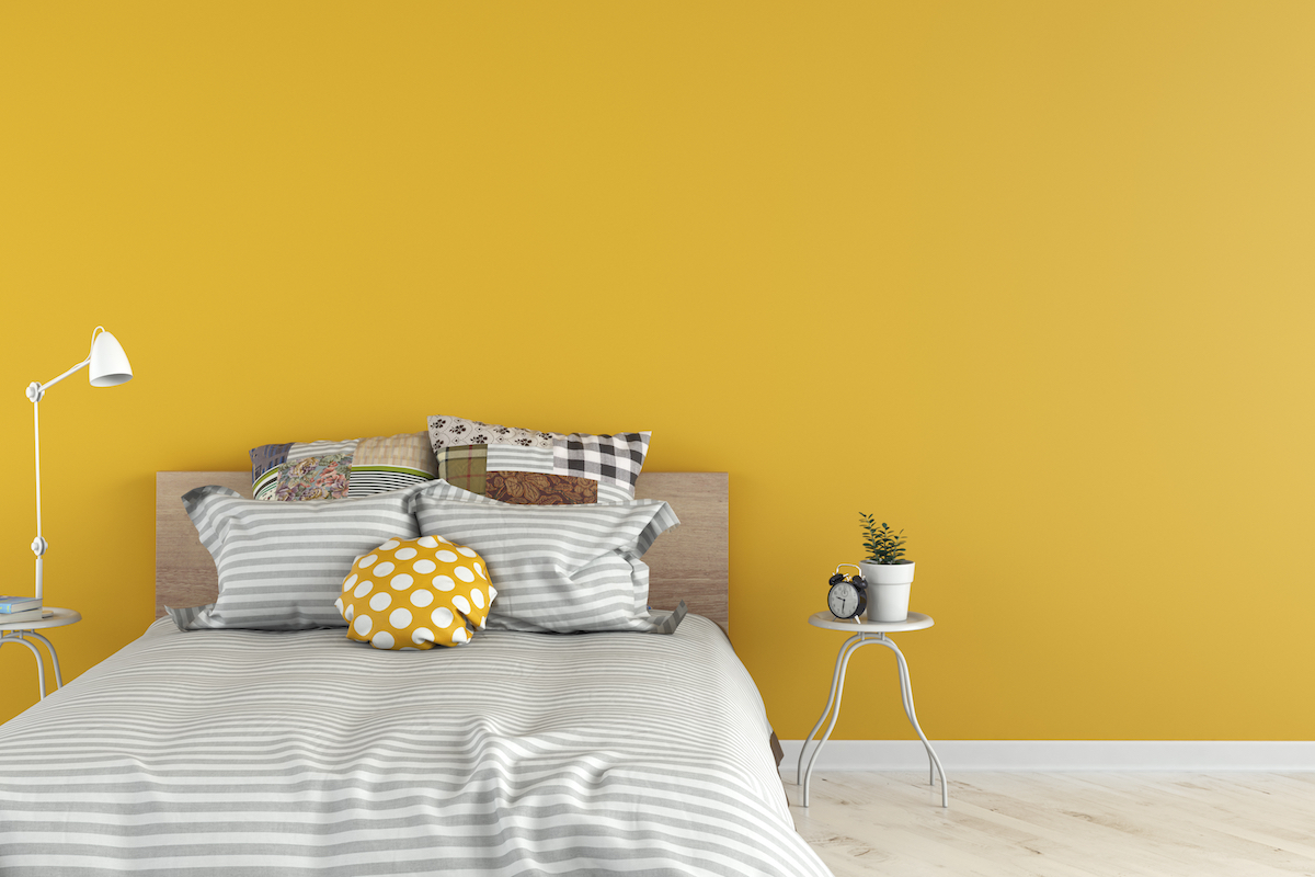 Bedroom with decoration on white hardwood floor in front of empty yellow wall