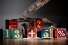 Children's building blocks are used to count from 1-5 with money inbetween the blocks.