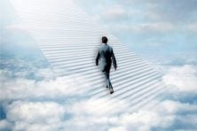 A man walks on a stairway in the clouds toward Heaven.