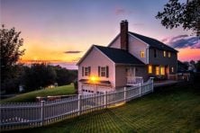 A house is photographed at sunset. Magenta hues fill the sky.