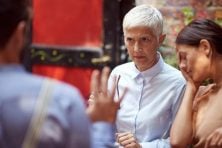 Stock image shows an older woman looking unhappy at a younger man while a younger woman looks stressed sitting next to the older woman.