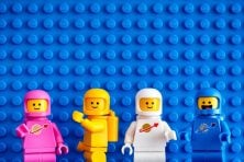 Astronaut Legos against a blue lego background.
