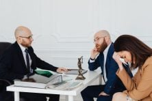 Couple learning from a lawyer they've about contents of a will