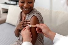 A woman gets a bandaid on her arm after getting a flu vaccine.