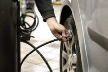 Person pumps air into their car tires.