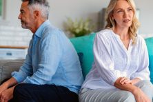 A couple have a disagreement while sitting on a couch.