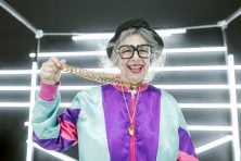Older woman shows off costume jewelry necklace she's wearing