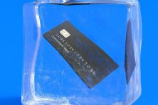 A credit card sits in a frozen block of ice.