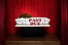 A past due notice appears on a coffin.