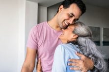 An adult son hugs his mother.