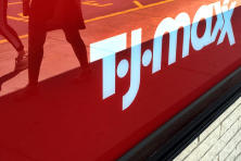 Shoppers are reflected as they walk by a T.J. Maxx storefront.