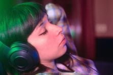 A woman listens to music on her headphones.