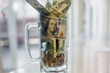 A beer mug is filled with money from tips.