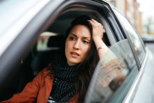 A woman waits in traffic.