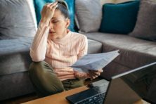A woman looks stressed out as she manages her finances.