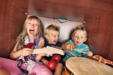 Three children play musical instruments.