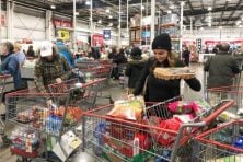 A woman waits at the checkout counter at Costco.