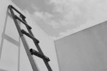 ladder against the side of a building reaching toward the sky