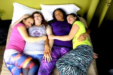 4 staff members from Cuddle Up To Me cuddling in a bed