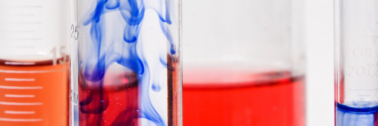 Graduated cylinders and beaker filled with chemical compounds