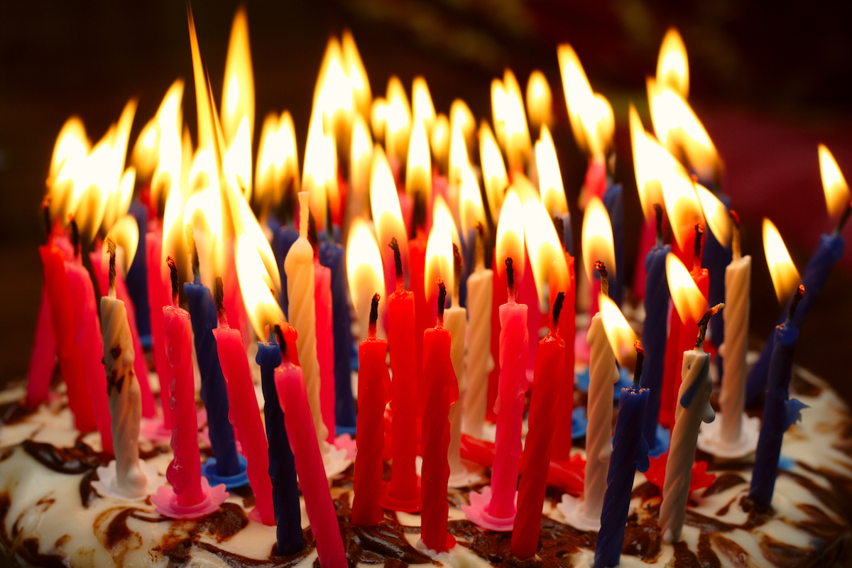 birthday cake with the lot of burning candles