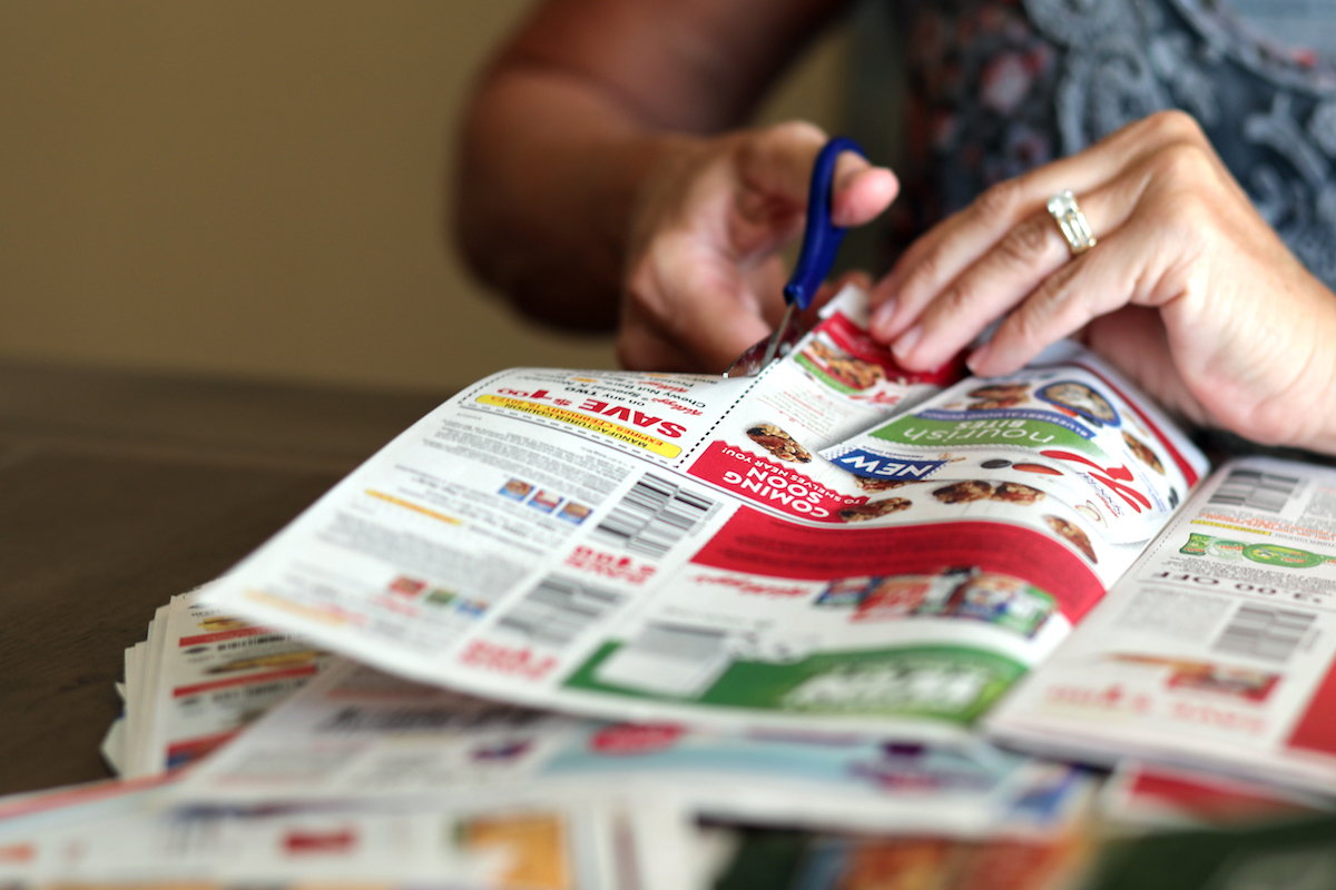 close up of hands cutting coupons
