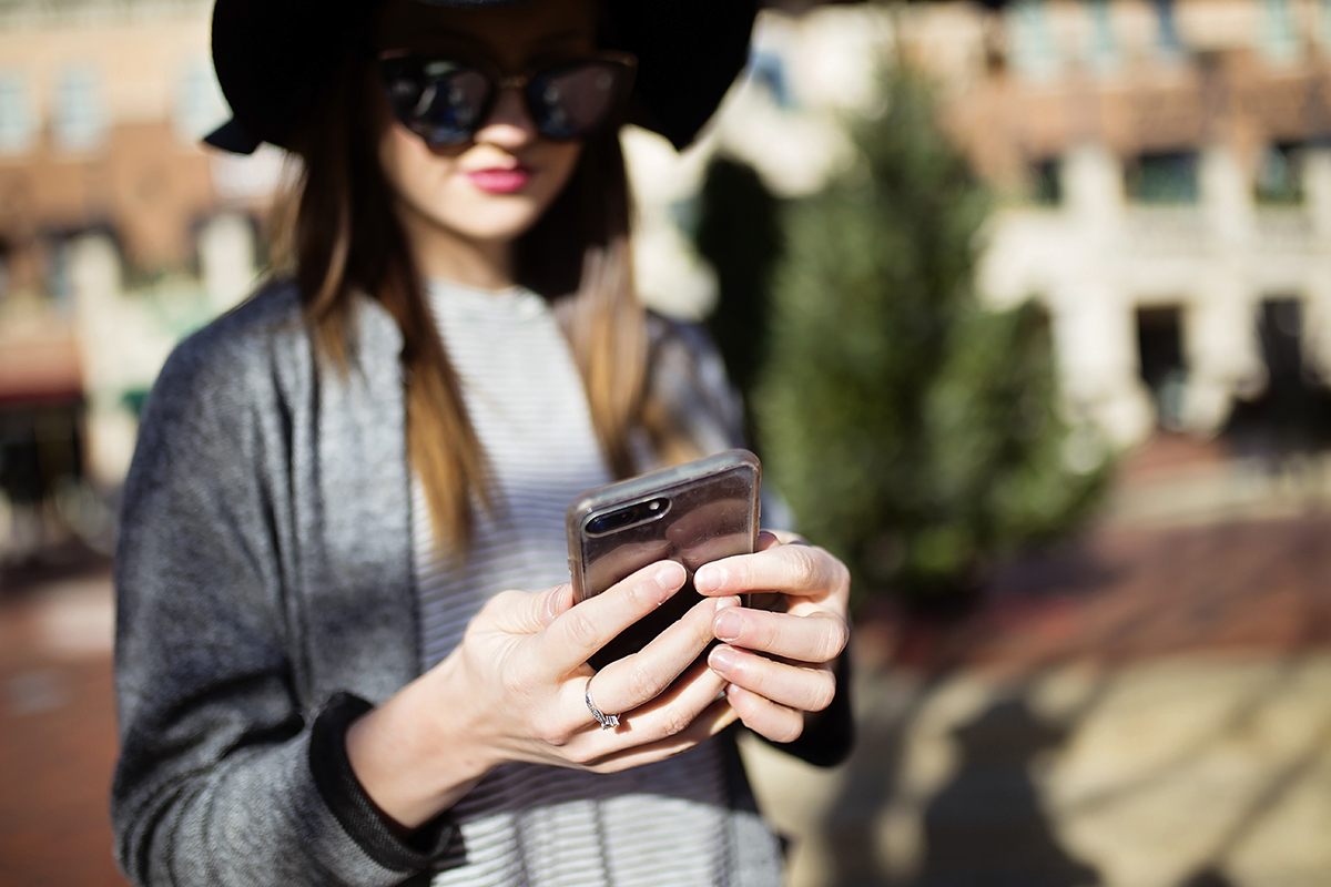 A woman holds a cell phone