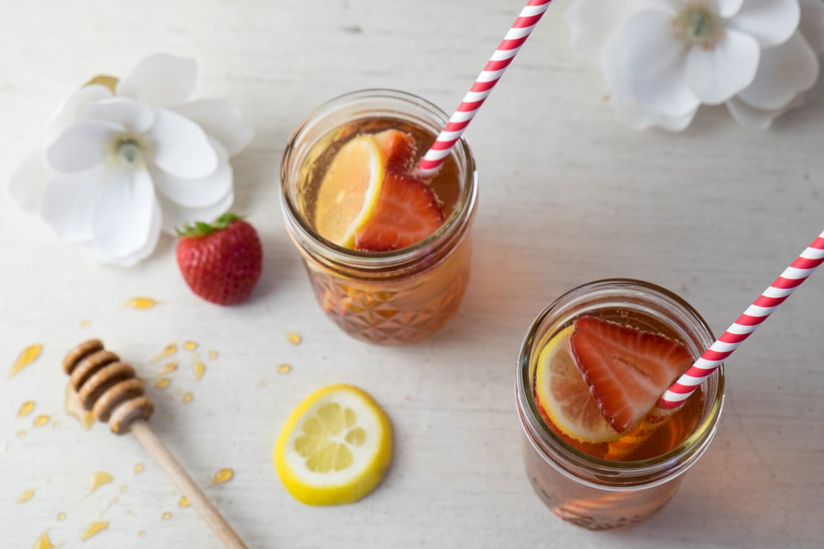 Two glasses of strawberry lemon pomegranate summer sangria is photographed. 