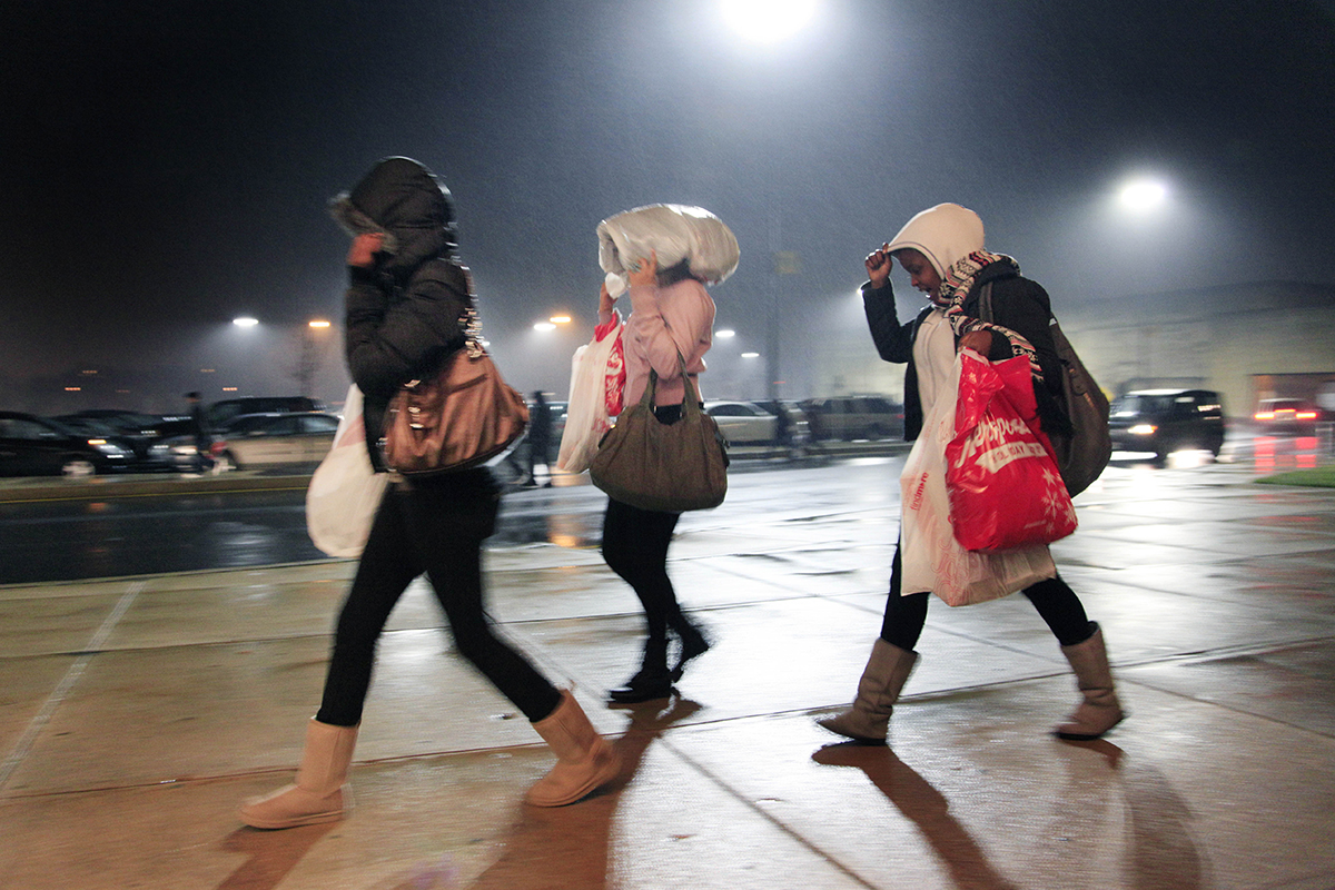 Early morning shoppers leave the Christiana Mall under a light rain, Friday, Nov. 26, 2010 in Christiana, Del.