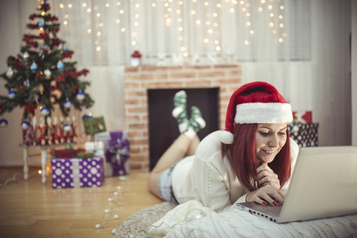 woman in santa hat using her laptop