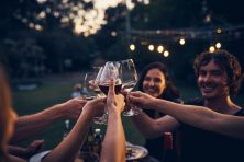 friends holding wine glasses while toasting