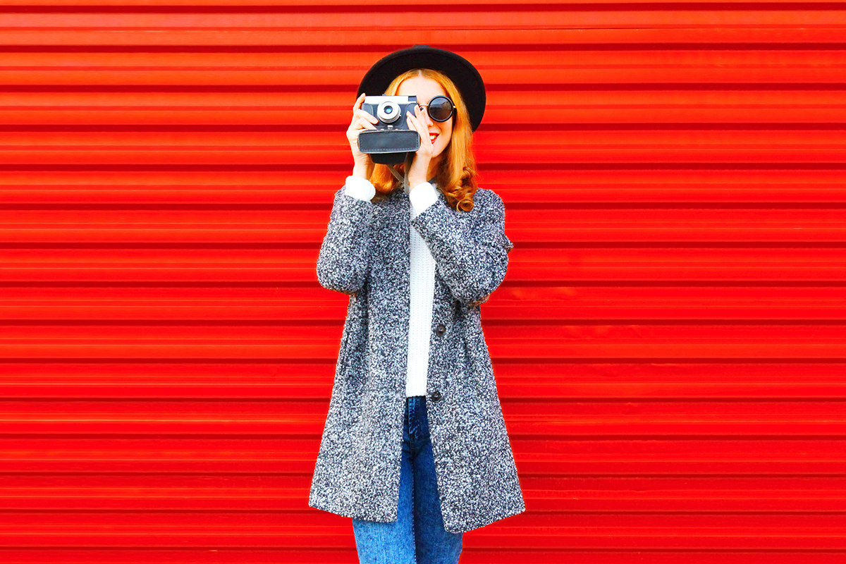 woman with retro camera on a red background