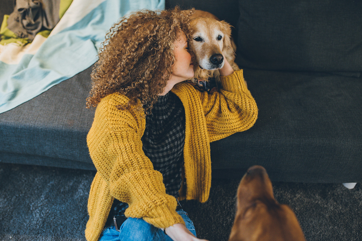 Woman playing with her dogs at home.