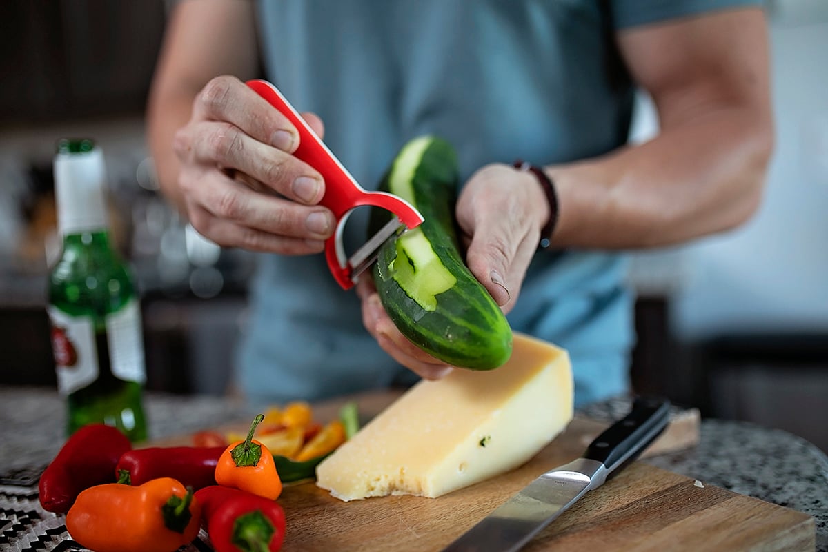 man peeling vegetables at home