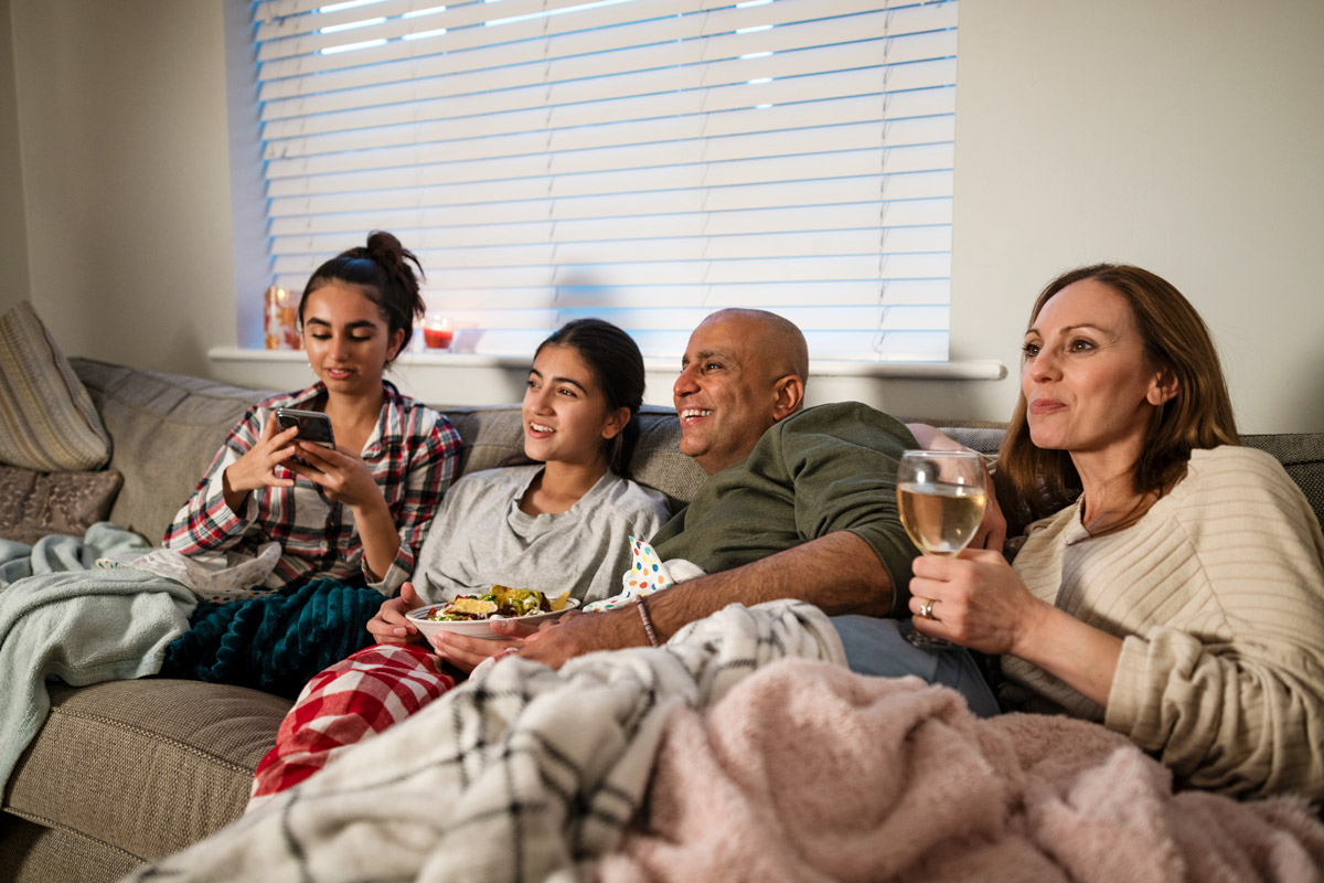 A family watch a movie together at home. 
