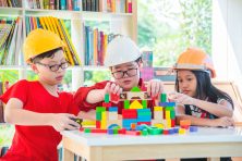 Three children play with legos at their local library.