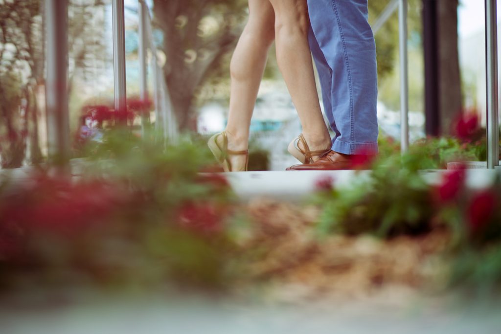 Two pairs of legs are shown, indicating that a man and a woman are standing very closely in front of each other.