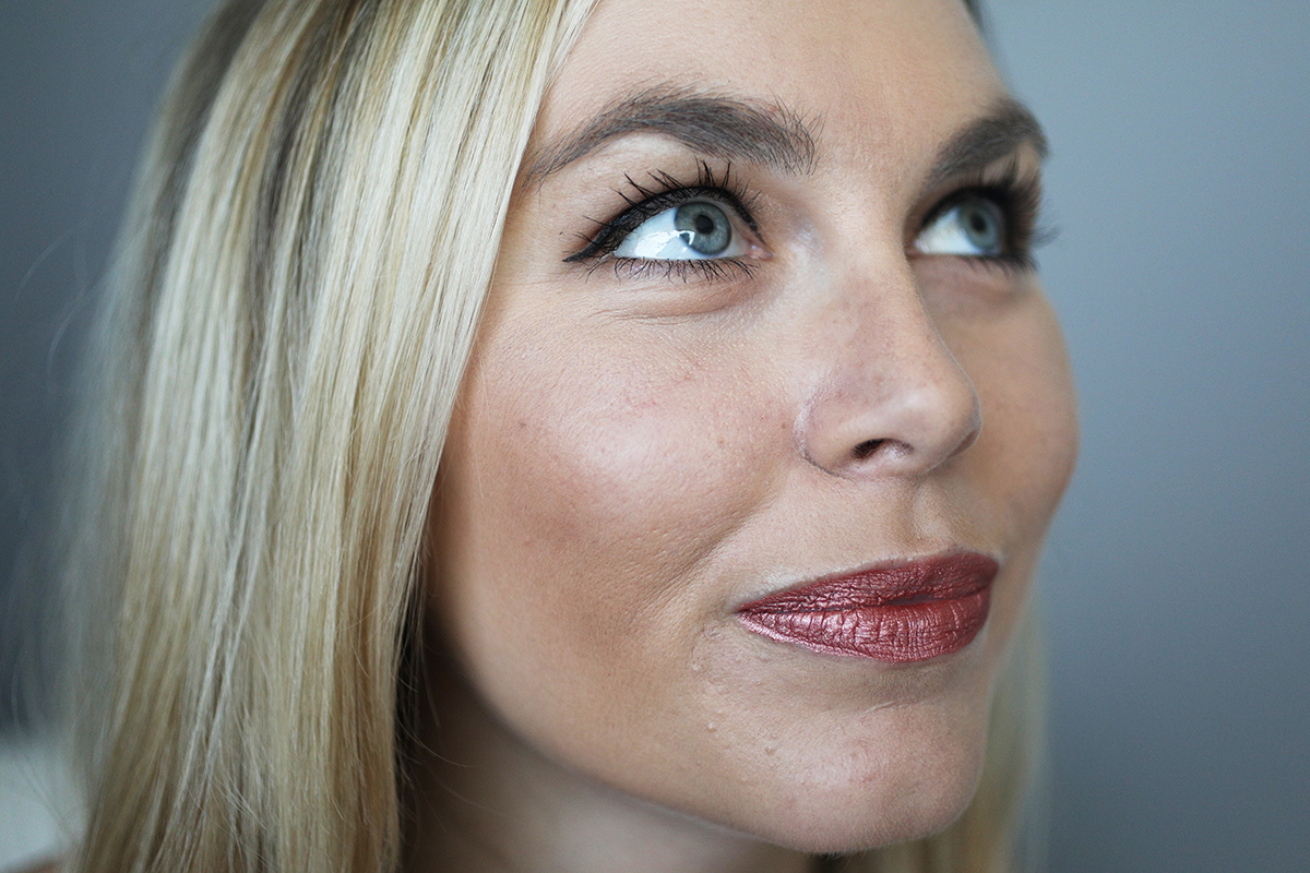 A woman tries on Milani Amore Matte lipstick.