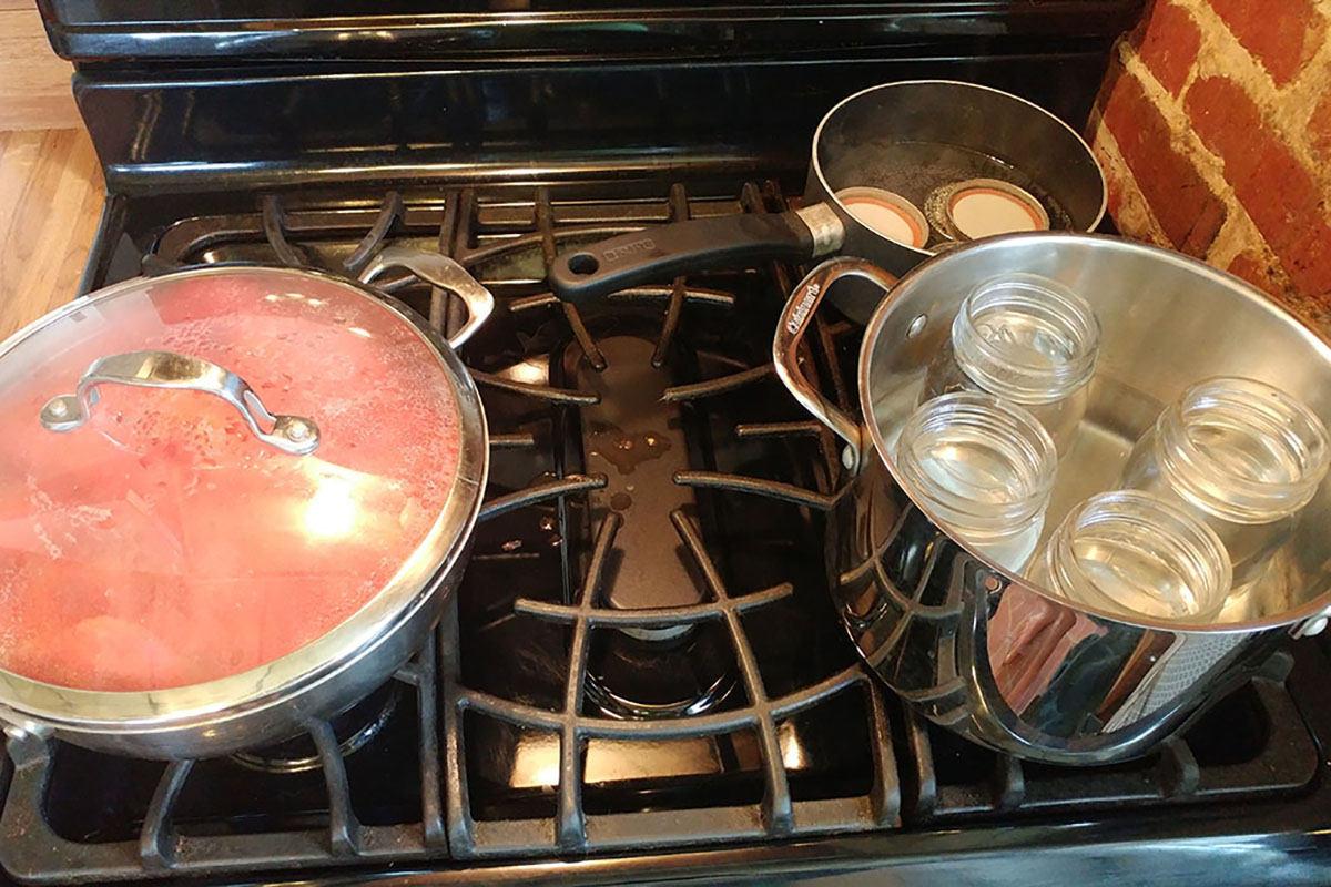 Tomatoes simmer on the stove while making canned tomatoes.