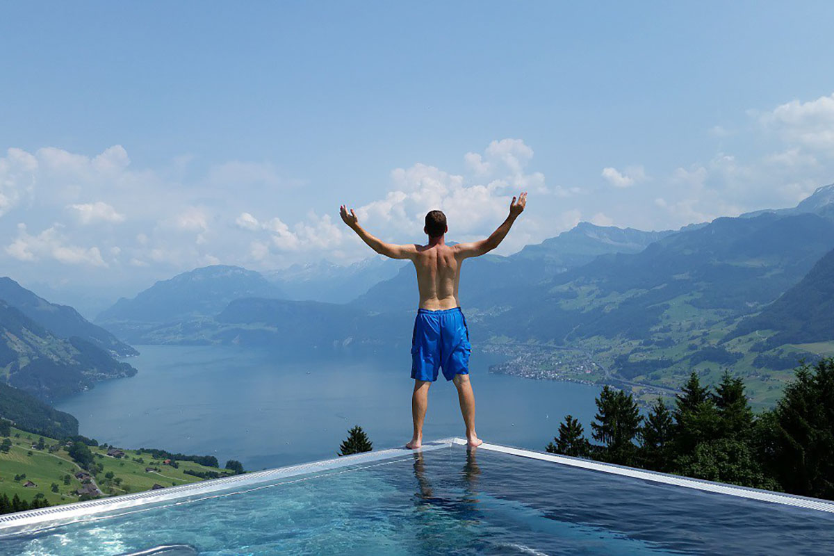 Greg Johnson takes in the view of mountains from a hotel pool while visiting Lucerne, Switzerland.