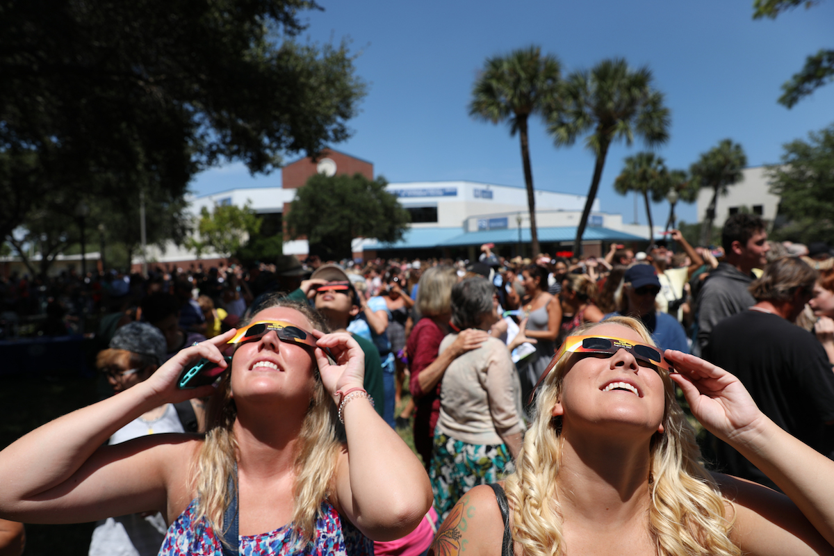 Kayla Boyer, left, and Alexis Corder wear protective glasses to watch a partial solar eclipse at St. Petersburg College on Monday August 21, 2017.