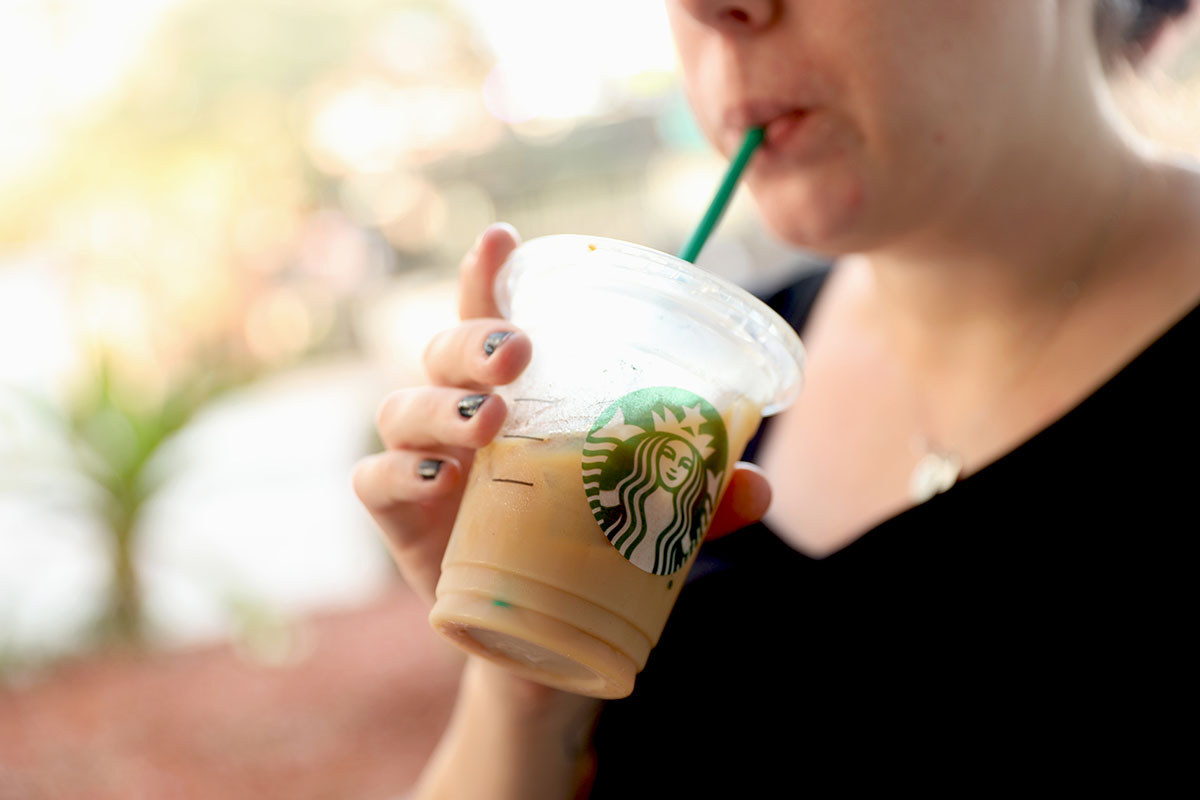 woman drinking iced starbucks beverage