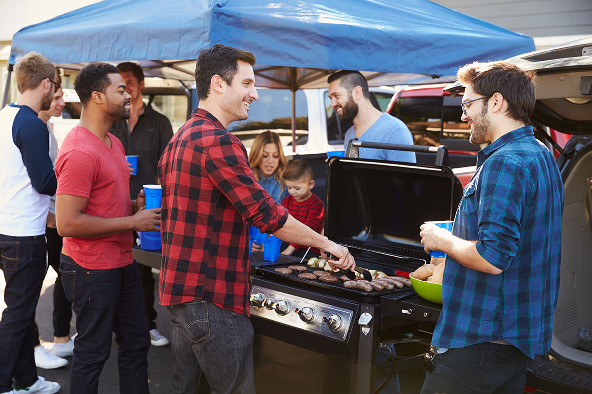 Group Of Sports Fans Tailgating In Stadium Car Parking lot