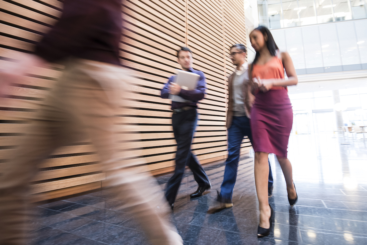 Business people walking in modern office with blurred motion