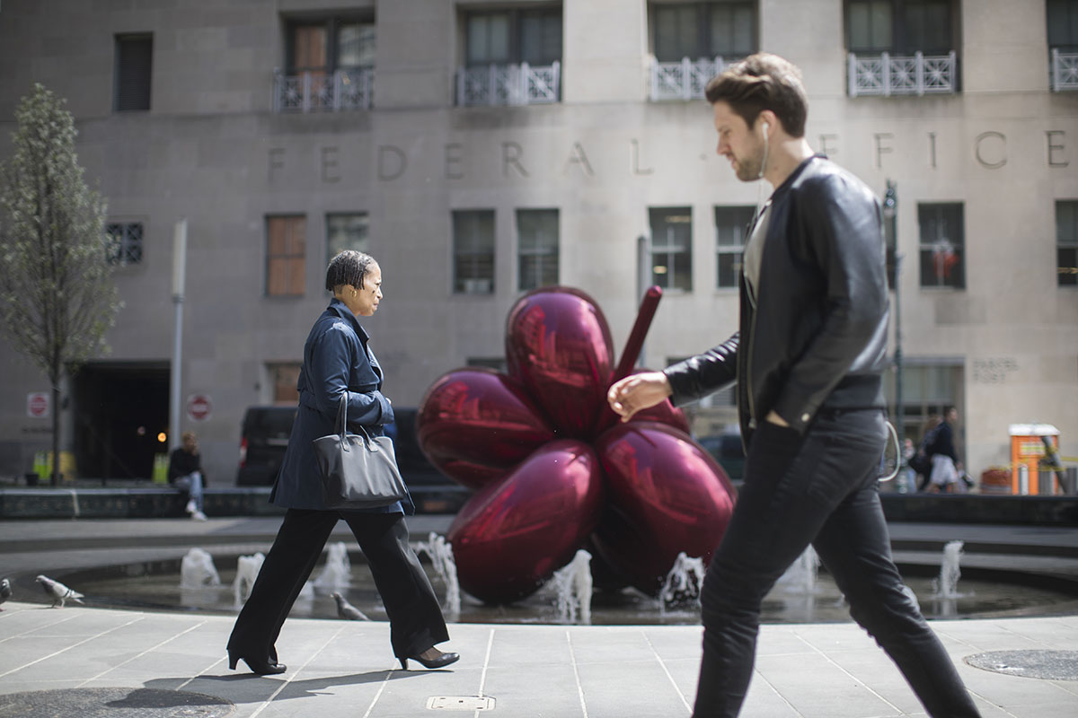 Pedestrians walk past a Jeff Koons sculpture in downtown Manhattan, Friday, April 14, 2017, in New York