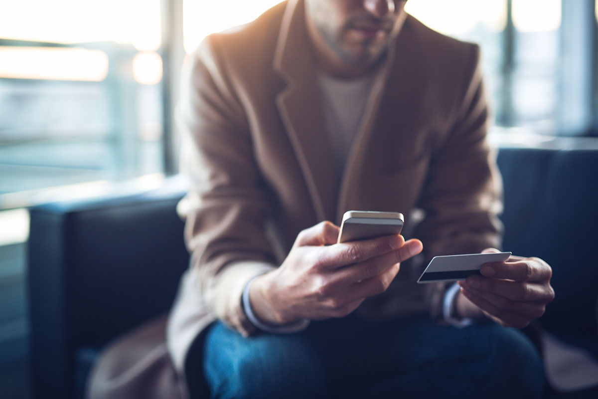 man checking credit card info on smartphone