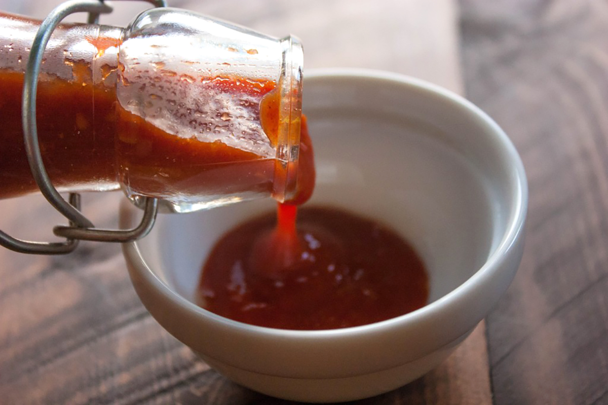 homemade ketchup being poured into a bowl