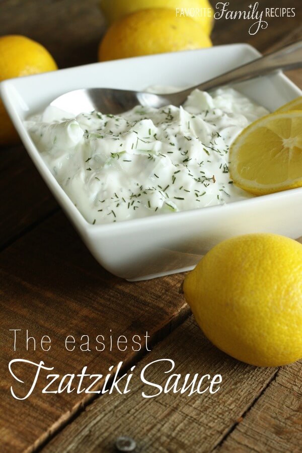 homemade tzatziki sauce in a white dish with lemons