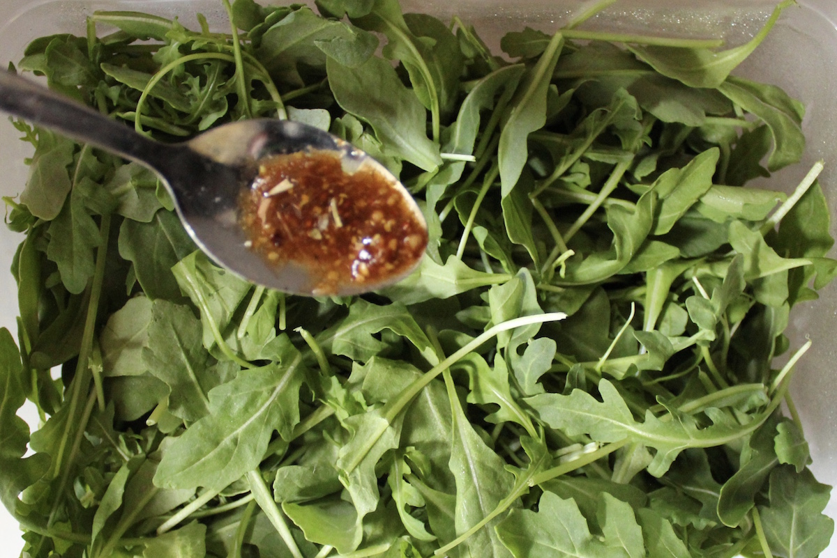 homemade salad dressing on a spoon over salad
