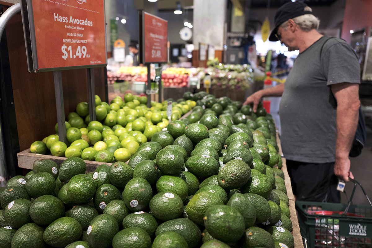 A customer shops for avocados at a Whole Foods Market, in New York Monday, Aug. 28, 2017.
